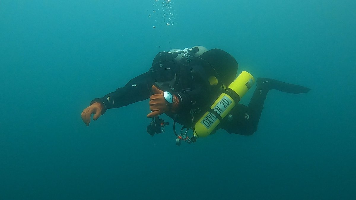 Kian scuba diving, giving a hand signal