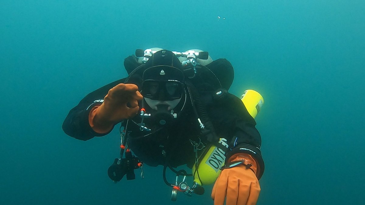 Kian scuba diving, facing the camera in full technical dive gear