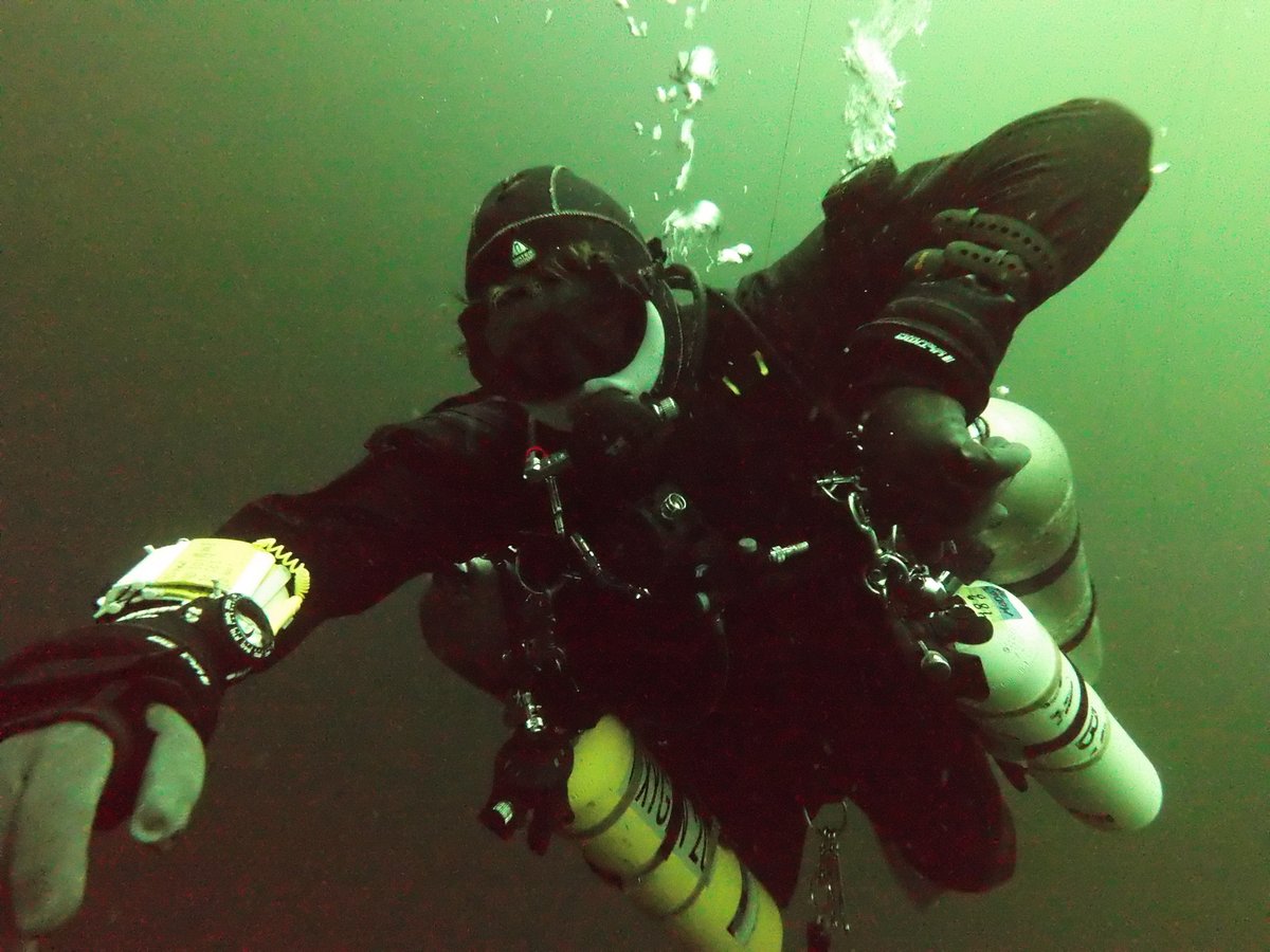Diver reaching toward the camera in a twinset