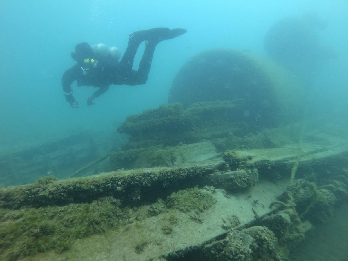 A diver swimming over the deck structure of a shipwreck